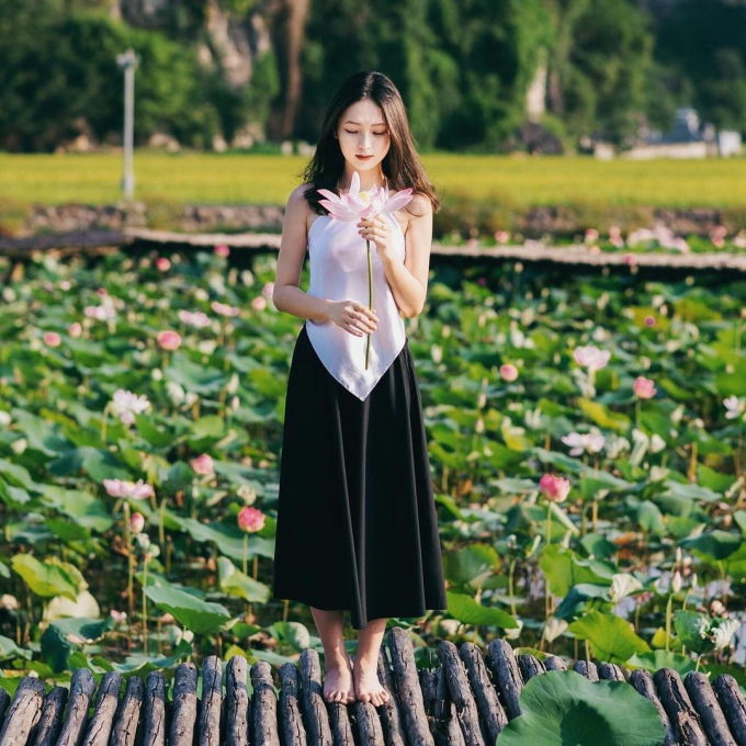 A young person takes a yearbook photo at Hang Mua lotus pond.  Photo: @23.4studio