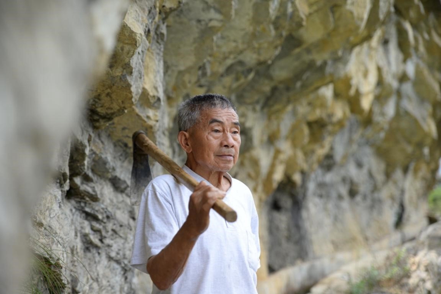 Mr. Huang once climbed a 300-meter-high cliff and tied himself to a tree there to work.  Despite the danger, he believes: 