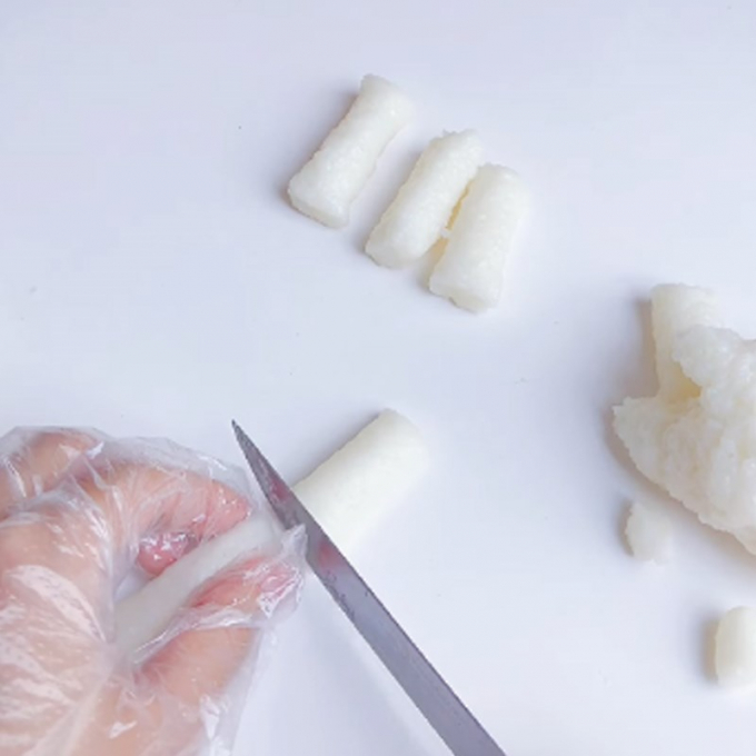 After kneading the rice into an oblong mass, spread some tapioca flour on the cutting board and cut the tokbokki into bite-sized pieces.