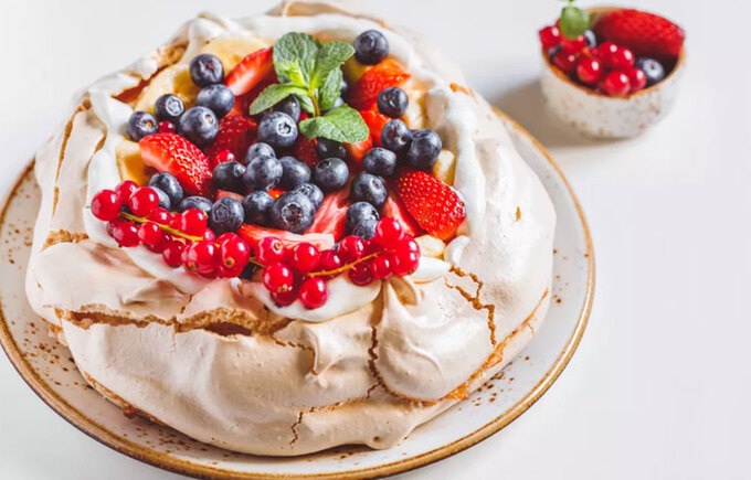 The cake is made from whipped cream, topped with a layer of custard made from snow sugar.  Then, people put on it a layer of fruit such as peaches, cherries, berries... Photo: Spruce Eats